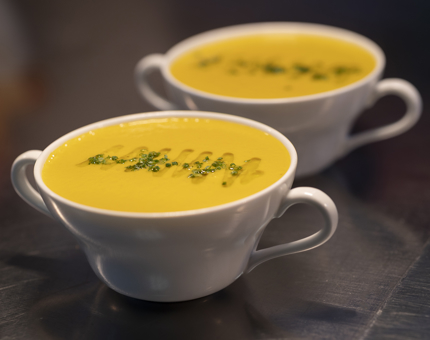 Two bowls of carrot and coriander soup. 