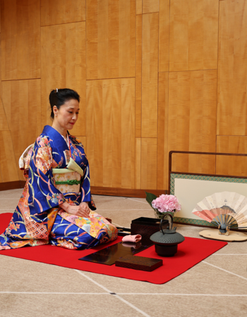 a woman in traditional Japanese kimono kneeling on the floor