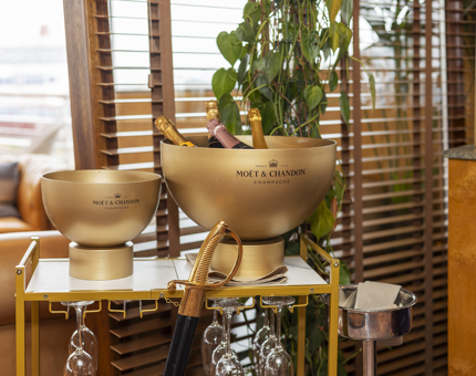 In The Lighthouse Restaurant, there is a gold drinks trolley with large basins containing bottles of Moet & Chandon Champagne.