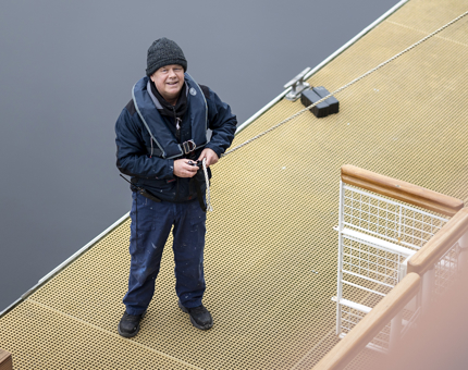 A Maintenance team member on the pontoon preparing ropes.