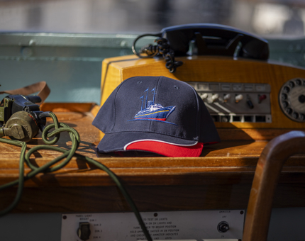 A navy blue and red cap with an embroidered image of Britannia on the front. 