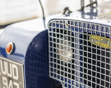 A close up of the front of a land rover car. 