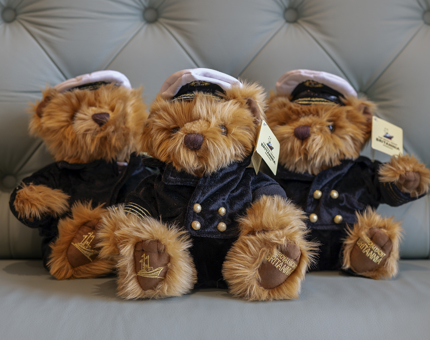 Three plush bears dressed at the ship's captain.