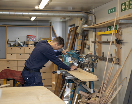Greig cutting wood for deck repairs to Britannia.