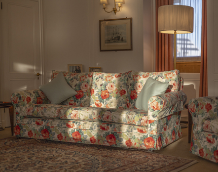 Afternoon sunlight creates shadows across a floral patterned couch in the State Drawing Room on Britannia in Leith.