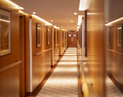 A corridor aboard Fingal hotel. There are framed pictures lining the hallway.