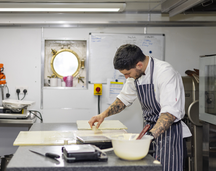 Junior Sous Chef, Bob, making chocolate decorations for a dessert to be served at an evening event. 
