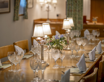 In the Officer's Wardroom, the long table is set and there are lamps lit in the middle. 