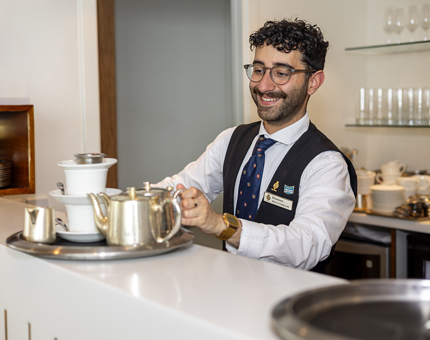 A member of the Tearoom team making drink at the bar. 