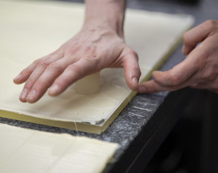 A close-up of hands preparing white chocolate.