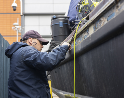 A Maintenance team member working on the Fast Motor Launch boat.